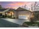 House exterior at sunset with a two-car garage at 310 Pine St, Locust, NC 28097
