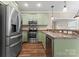 Modern kitchen with stainless steel appliances and green cabinets at 310 Pine St, Locust, NC 28097