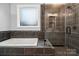Elegant bathroom boasting a soaking tub and a walk-in shower with sleek, dark gray tile at 357 Triple Ponds Ct, Clover, SC 29710