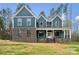 Two-story home featuring a blend of brick and blue siding, complemented by a welcoming front porch at 357 Triple Ponds Ct, Clover, SC 29710