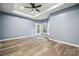 A light-filled room featuring a tray ceiling, wood-look floors and an exit to the rear of the home at 357 Triple Ponds Ct, Clover, SC 29710
