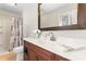 Well-lit bathroom with a cherry wood vanity, ample counter space, and decorative mirror at 1065 Gauguin Ln, Fort Mill, SC 29708