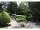 Serene backyard view with lush greenery, stone creek bed, and bridge leading to a manicured lawn area at 194 E Jay Dr # 3, Taylorsville, NC 28681