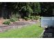 Beautiful backyard with wooden retaining wall and white privacy fence with lots of greenery at 194 E Jay Dr # 3, Taylorsville, NC 28681