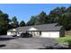 Well-maintained exterior view of a multi-unit building with ample parking and a lush tree line in the background at 194 E Jay Dr # 3, Taylorsville, NC 28681