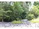 Natural landscaping with boulders, flowers, and trees lining the perimeter of the property at 194 E Jay Dr # 3, Taylorsville, NC 28681
