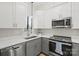 Modern kitchen with gray and white cabinets and stainless steel appliances at 224 N Poplar St # 16, Charlotte, NC 28202