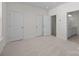 Spacious bedroom featuring neutral carpet, two doors and doorway that leads to an attached bathroom at 5027 Layman Dr # 24, Charlotte, NC 28226