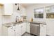 Modern kitchen with white cabinets and a farmhouse sink at 6521 Heatherbrook Ave, Charlotte, NC 28213