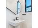 Stylish pedestal sink with black hardware and a framed mirror at 819 E 36Th St, Charlotte, NC 28205
