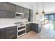 Modern kitchen featuring gray cabinets, stainless steel appliances, and an open layout to the living area at 819 E 36Th St, Charlotte, NC 28205