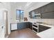Bright kitchen featuring gray cabinetry, white countertops, stainless steel appliances, and hardwood floors at 819 E 36Th St, Charlotte, NC 28205