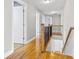 Upstairs hallway with hardwood floors and a wooden railing overlooking the staircase at 8217 Curico Ln, Charlotte, NC 28227