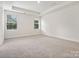 Large, well-lit bedroom with tray ceilings, carpet floors, and two bright windows at 1063 Bull Dog Ln, Wingate, NC 28174