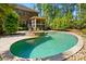 Beautiful backyard with a pool and spa, complemented by lush landscaping and brick home exterior at 16515 Governors Club Ct, Charlotte, NC 28278