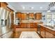 Spacious kitchen featuring stainless steel appliances, wooden cabinets, granite counters and hardwood floors at 16515 Governors Club Ct, Charlotte, NC 28278