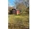 Red storage shed in a spacious yard, providing extra storage space and a rustic charm at 116 Lodge Hall Ct, Stony Point, NC 28678