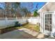 Private backyard with a white fence, small patio, and a door to access the house at 1305 Penny Oaks Cv, Rock Hill, SC 29732