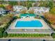 Community pool with blue water surrounded by green trees and the roofs of townhomes at 1305 Penny Oaks Cv, Rock Hill, SC 29732