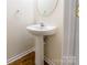 Stylish powder room featuring a pedestal sink, modern faucet, and round mirror at 1305 Penny Oaks Cv, Rock Hill, SC 29732