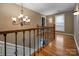 Upstairs hallway featuring hardwood floors, a chandelier, and wrought iron banister at 3513 Country Club Dr, Gastonia, NC 28056