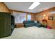 Cozy living room featuring wood paneling, a comfortable sectional sofa, and natural light at 3513 Country Club Dr, Gastonia, NC 28056