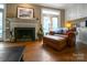 Cozy living room featuring a fireplace, hardwood floors, and a comfortable leather chair with ottoman at 3513 Country Club Dr, Gastonia, NC 28056