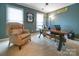Comfortable home office with a unique desk, cozy chair, and natural light from two windows at 3513 Country Club Dr, Gastonia, NC 28056