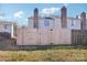 Backyard view of townhomes with brick chimneys and a privacy fence at 5300 Fair Wind Ln, Charlotte, NC 28212