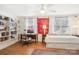 Well-lit bedroom features a ceiling fan, a built-in bookcase, a desk, and white curtains at 5300 Fair Wind Ln, Charlotte, NC 28212