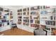 Bright room showcases floor-to-ceiling bookshelves, with ladder, and an upholstered chair at 5300 Fair Wind Ln, Charlotte, NC 28212