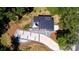 Aerial view of modern home with metal roof, gravel driveway, and lush landscaping at 6534 Providence Rd, Charlotte, NC 28226