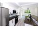 Open-concept kitchen with white cabinets, stainless appliances, and large island with sink at 6534 Providence Rd, Charlotte, NC 28226