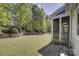 Beautiful backyard view features retaining wall, lush greenery, and screen porch at 10029 Daufuskie Dr, Charlotte, NC 28278