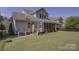 Rear view of a gray two-story house, with a backyard and screened in porch at 10029 Daufuskie Dr, Charlotte, NC 28278