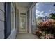 Inviting front porch with a decorative column and black railing, offering a glimpse of the outdoors at 10029 Daufuskie Dr, Charlotte, NC 28278