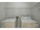 Functional laundry room with washer, dryer, and wire shelving for storage at 10029 Daufuskie Dr, Charlotte, NC 28278