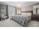 Calm bedroom features carpet, queen bed, side tables with lamps, and neutral wall color at 1655 Scotland Ave, Charlotte, NC 28207