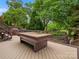 Deck featuring a pool table, covered seating, and lush backyard landscape at 1655 Scotland Ave, Charlotte, NC 28207