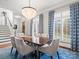 Elegant dining room featuring a crystal chandelier, shuttered windows, and a stylish blue rug at 1655 Scotland Ave, Charlotte, NC 28207