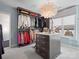 Large walk-in closet with custom shelving and an island, illuminated by a stylish pendant light at 1655 Scotland Ave, Charlotte, NC 28207