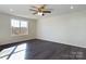Bright bedroom with ceiling fan, large window, and dark gray flooring at 2061 Gary Ln, Hickory, NC 28602