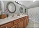 Bathroom with dual sinks, decorative mirrors, and tiled floor at 2481 Bergamot St, Tega Cay, SC 29708