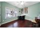 This bedroom is painted in light-green, with hardwood flooring and a bright window at 2481 Bergamot St, Tega Cay, SC 29708