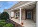 Inviting covered front porch with seating area, brick facade, and well-maintained landscaping at 2481 Bergamot St, Tega Cay, SC 29708