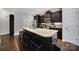 This modern kitchen features a large granite island with seating and sleek dark wood cabinetry at 2481 Bergamot St, Tega Cay, SC 29708