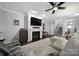 Spacious living room with a cozy fireplace, mounted TV, and access to the stairway and kitchen at 2481 Bergamot St, Tega Cay, SC 29708