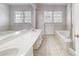 Bright and expansive bathroom featuring double sinks, a soaking tub, and tiled floors at 2605 Willowdale Ln, Matthews, NC 28105