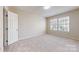 Bedroom featuring a large window, neutral carpet and paint, and an interior access door at 2605 Willowdale Ln, Matthews, NC 28105