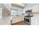 Kitchen features stainless appliances, white cabinetry, solid surface countertops, and wood floors at 2605 Willowdale Ln, Matthews, NC 28105